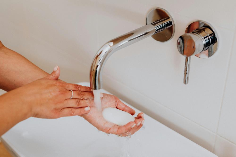 A person washing their hands in a sink