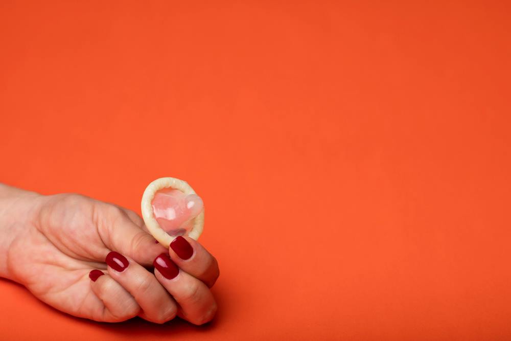 A woman holding a condom