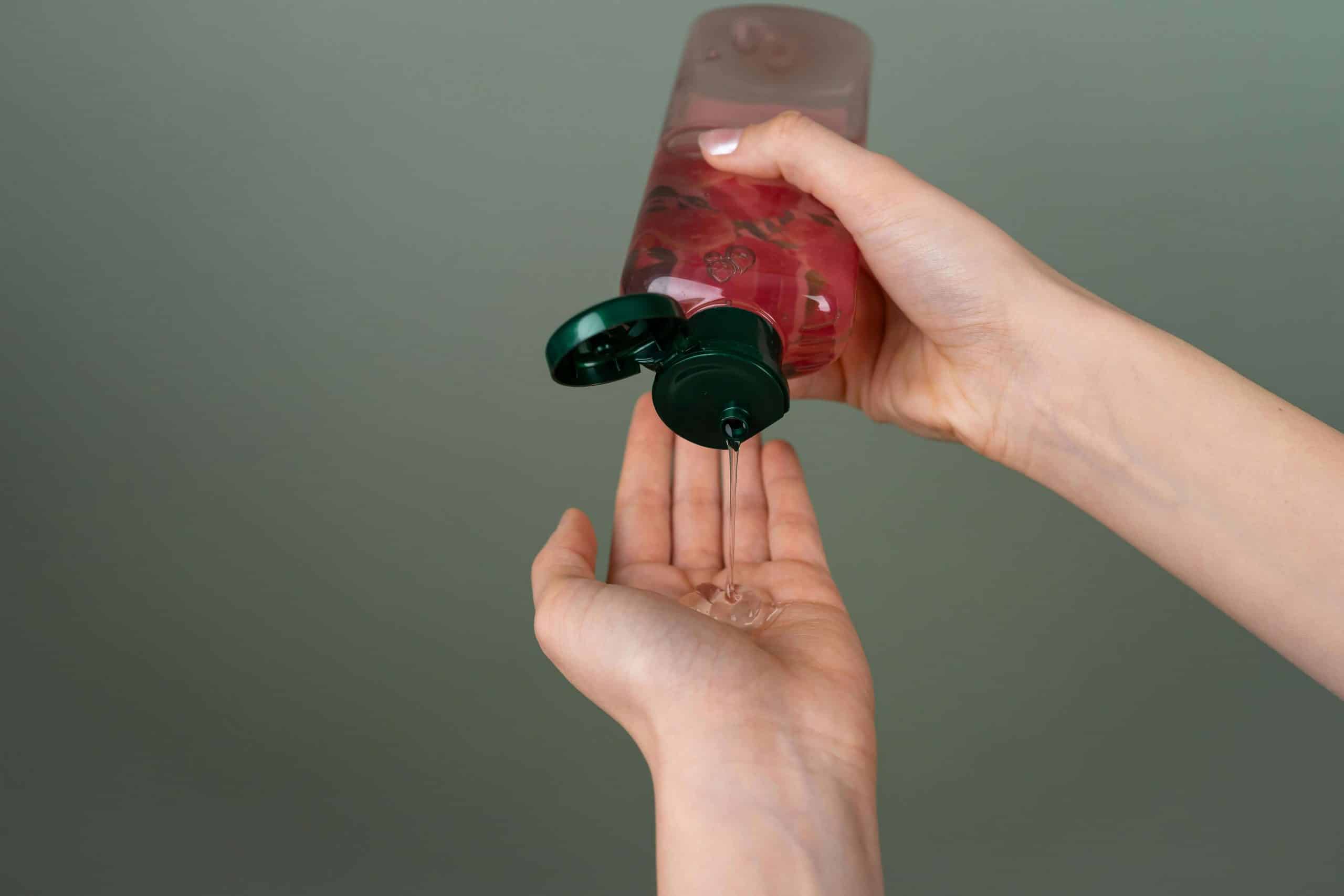 a person squeezing lubricant out of a bottle
