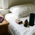 Pocket pussy sleeve and fleshlight canister side by side on a bed with lubricant